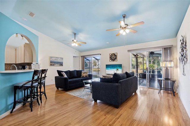 living room featuring lofted ceiling, plenty of natural light, light hardwood / wood-style floors, and ceiling fan