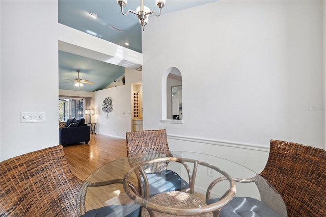 sitting room with hardwood / wood-style flooring, lofted ceiling, and ceiling fan with notable chandelier