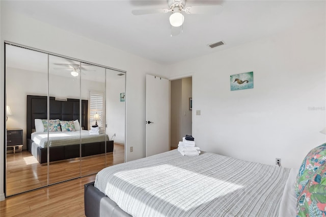 bedroom with hardwood / wood-style flooring, a closet, and ceiling fan