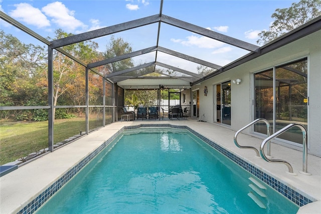 view of pool featuring a yard, glass enclosure, and a patio