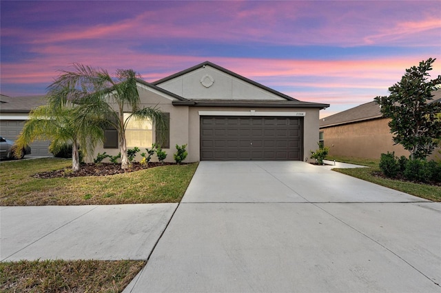 view of front of property featuring a garage and a lawn