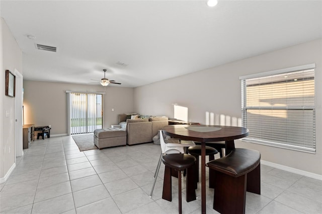 dining space featuring a ceiling fan, visible vents, baseboards, and light tile patterned flooring