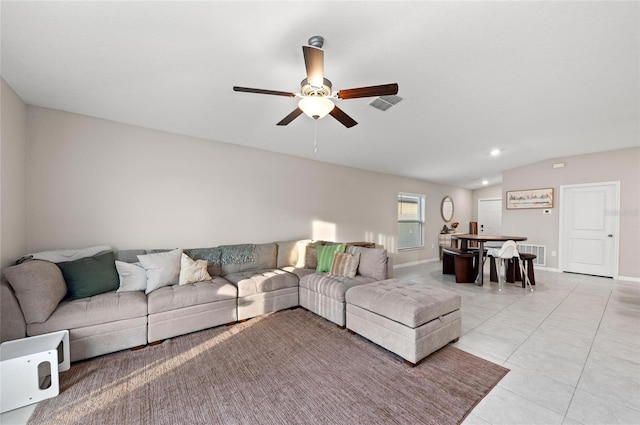 living room with a ceiling fan, light tile patterned flooring, vaulted ceiling, and visible vents