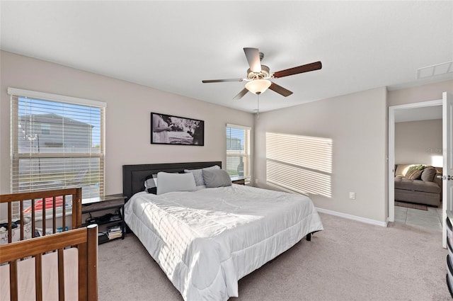 bedroom featuring light carpet, baseboards, visible vents, and a ceiling fan