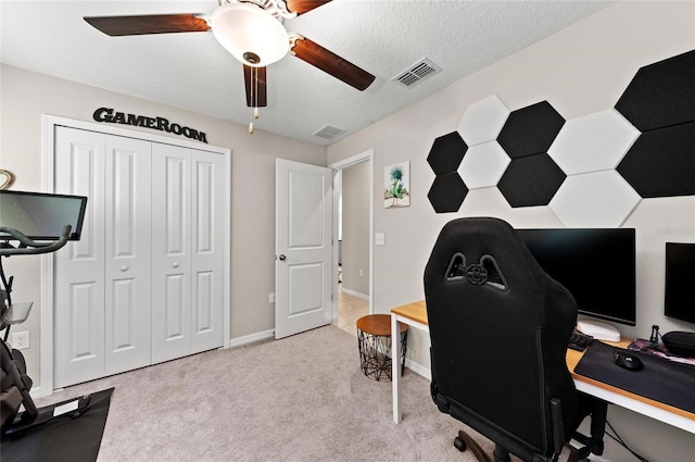 office space featuring baseboards, visible vents, a ceiling fan, a textured ceiling, and carpet flooring