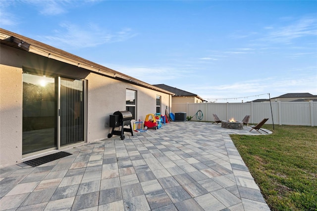 view of patio with area for grilling, an outdoor fire pit, central AC unit, and fence