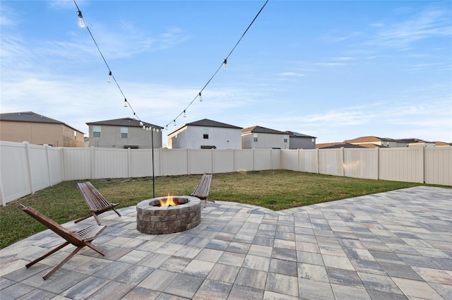 view of patio with an outdoor fire pit, a fenced backyard, and a residential view