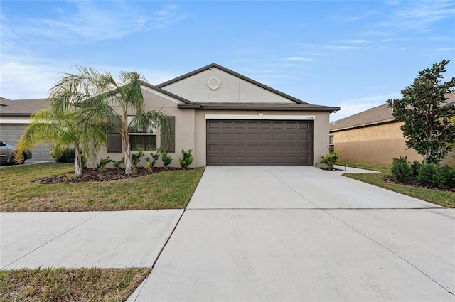 ranch-style home featuring a garage, driveway, a front yard, and stucco siding