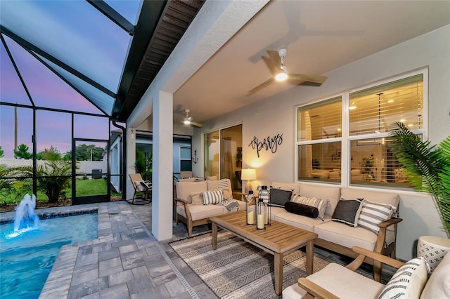 patio terrace at dusk with an outdoor hangout area, ceiling fan, and glass enclosure