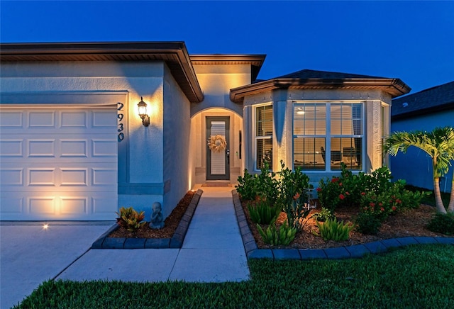 view of front of house with an attached garage and stucco siding