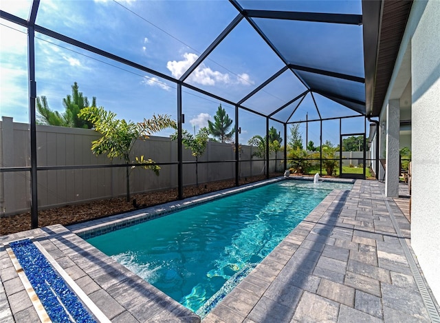 view of pool with a fenced in pool, glass enclosure, a fenced backyard, and a patio