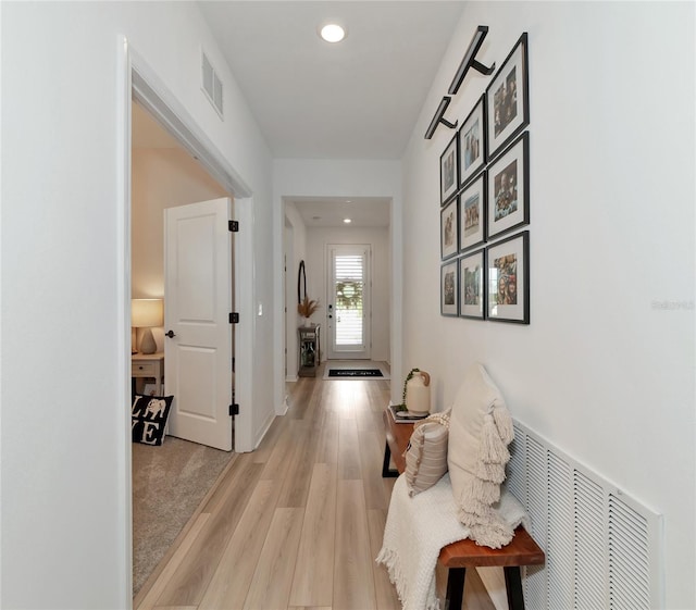 hall featuring light wood-style floors, recessed lighting, visible vents, and baseboards