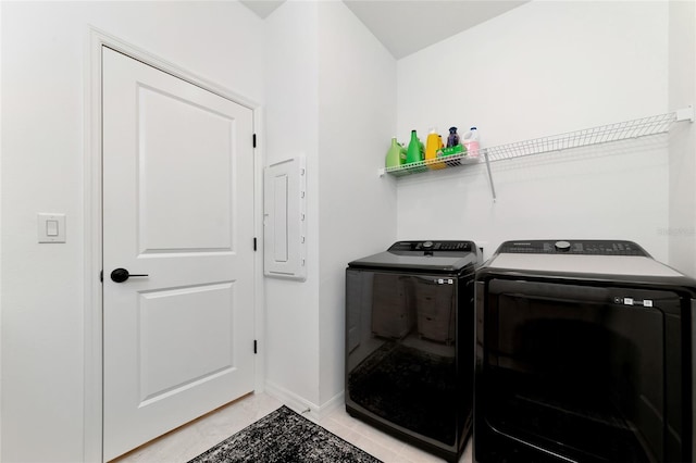 laundry room featuring light tile patterned flooring, laundry area, baseboards, electric panel, and washer and clothes dryer