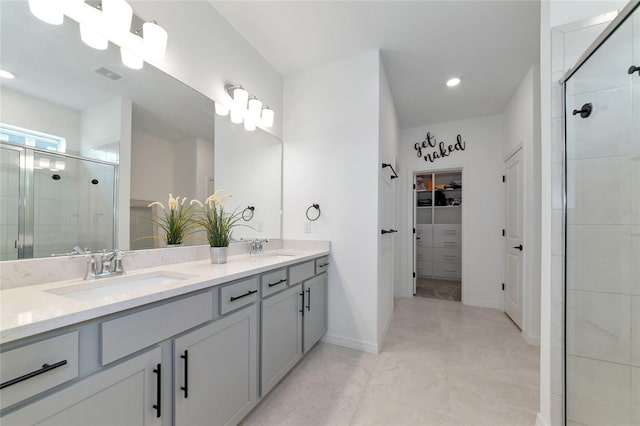 full bathroom featuring a spacious closet, a stall shower, a sink, and visible vents