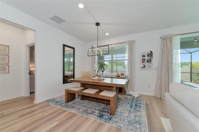 dining area with light wood-style floors, visible vents, and a healthy amount of sunlight