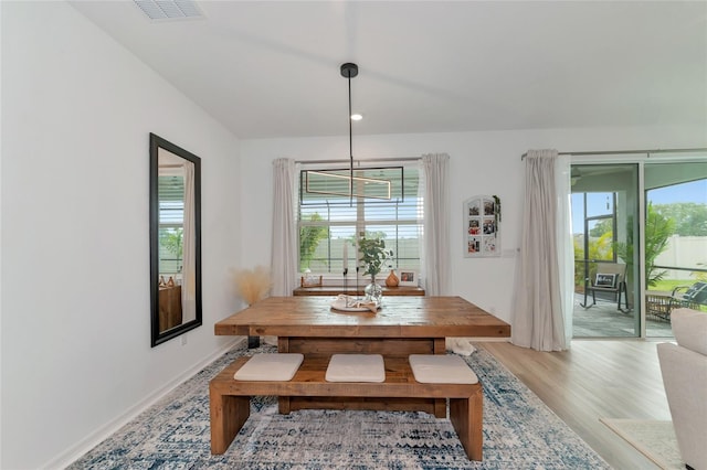 dining area with light wood finished floors, plenty of natural light, visible vents, and baseboards