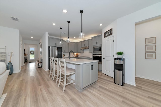 kitchen with visible vents, appliances with stainless steel finishes, gray cabinets, and a sink