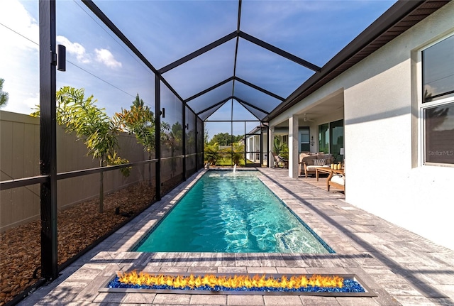 view of swimming pool with a lanai, fence, a fenced in pool, a patio area, and an outdoor living space with a fire pit