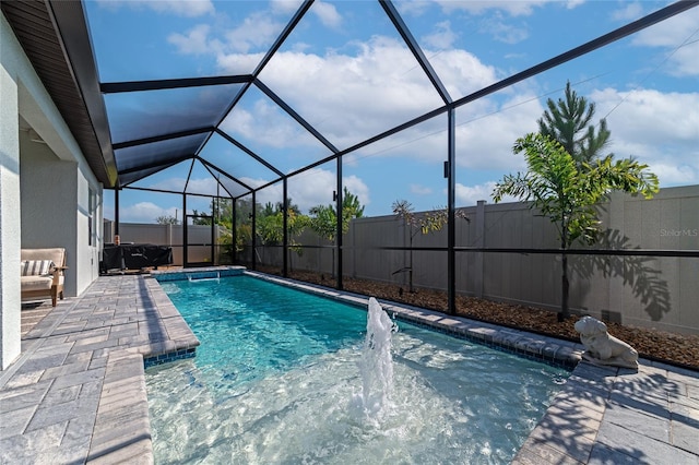 view of swimming pool with a patio, a fenced backyard, glass enclosure, and a fenced in pool