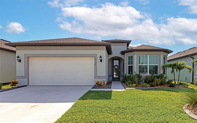 view of front of home featuring a front lawn, driveway, an attached garage, and stucco siding