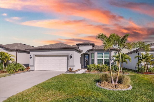 view of front of house with an attached garage, driveway, a front lawn, and stucco siding