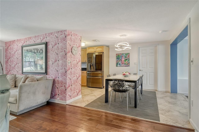 dining space with visible vents, a chandelier, light wood-type flooring, baseboards, and wallpapered walls