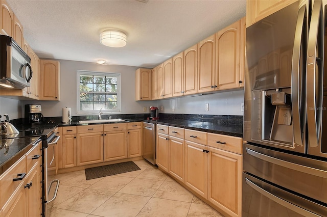 kitchen featuring light brown cabinetry, sink, and appliances with stainless steel finishes