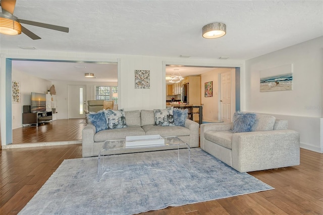 living area with visible vents, a textured ceiling, and hardwood / wood-style floors