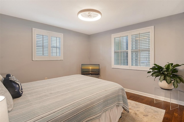 bedroom with dark wood-style flooring and baseboards