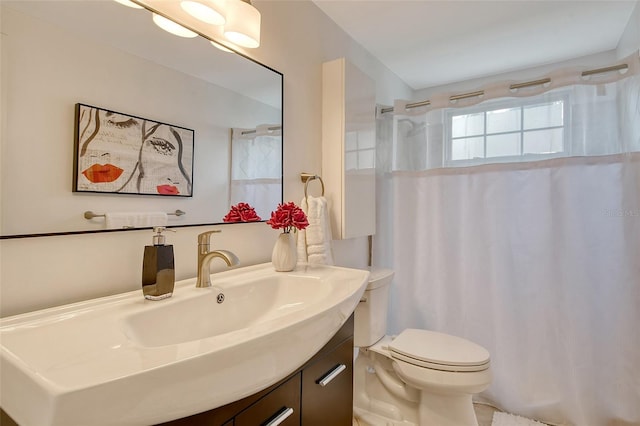 bathroom featuring curtained shower, vanity, and toilet