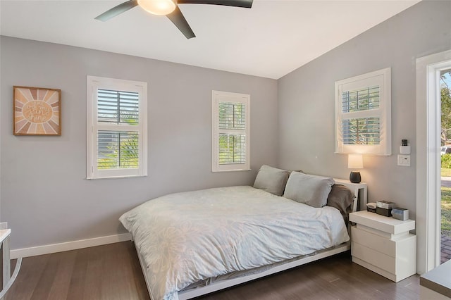 bedroom featuring lofted ceiling, ceiling fan, dark wood-style flooring, and baseboards