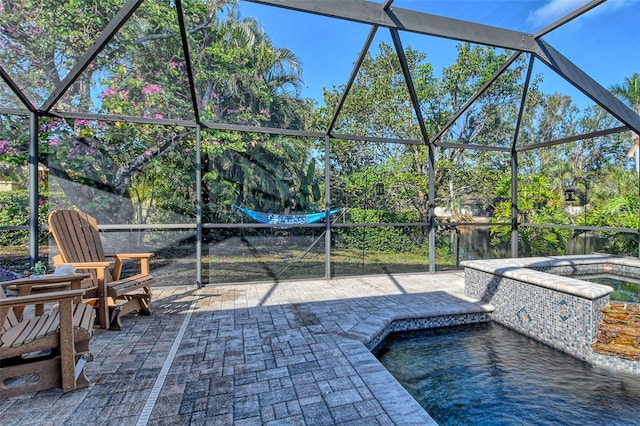 view of patio / terrace featuring a hot tub, a water view, and glass enclosure