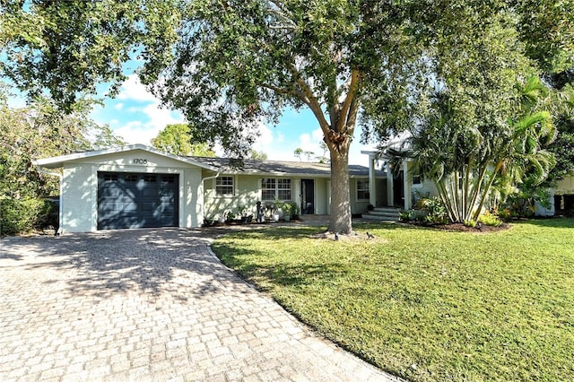 ranch-style home with a garage, a front lawn, and decorative driveway