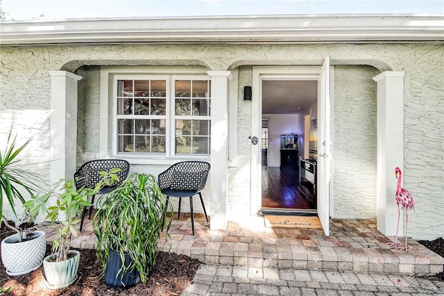 entrance to property featuring stucco siding