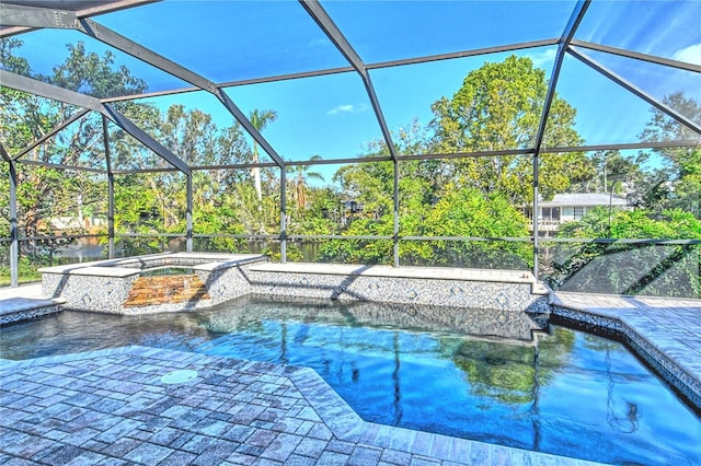 outdoor pool with glass enclosure, a patio, and an in ground hot tub