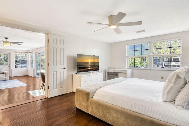 bedroom featuring visible vents, dark wood finished floors, baseboards, and ceiling fan