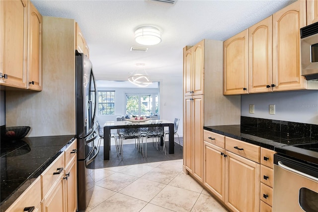 kitchen with light tile patterned floors, tile counters, visible vents, appliances with stainless steel finishes, and light brown cabinets