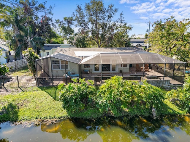 rear view of house featuring an outdoor pool, a lawn, glass enclosure, a fenced backyard, and a patio area