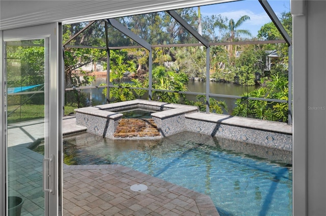 pool featuring glass enclosure, a patio, a water view, and an in ground hot tub