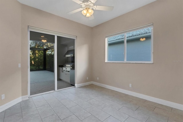 spare room featuring ceiling fan, a healthy amount of sunlight, and light tile patterned floors