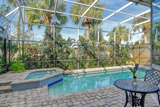 view of swimming pool with a patio, glass enclosure, and an in ground hot tub