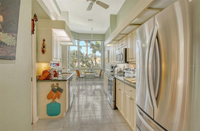 kitchen with appliances with stainless steel finishes, sink, pendant lighting, and cream cabinets