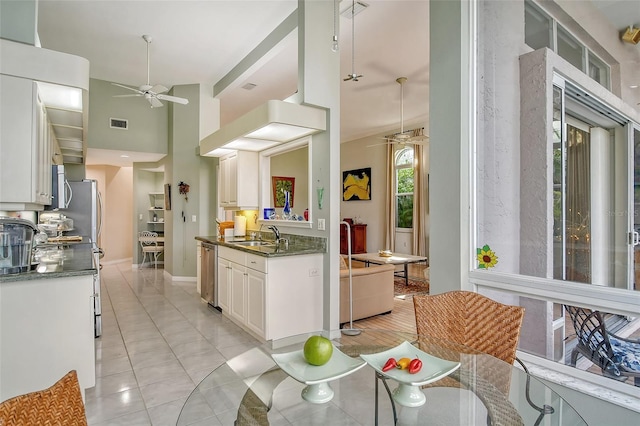 kitchen featuring appliances with stainless steel finishes, white cabinetry, sink, a high ceiling, and ceiling fan