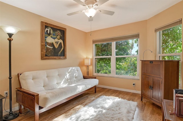 living area with ceiling fan, plenty of natural light, and light hardwood / wood-style floors