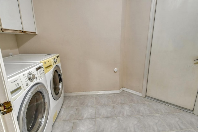 laundry room with independent washer and dryer, cabinets, and light tile patterned flooring