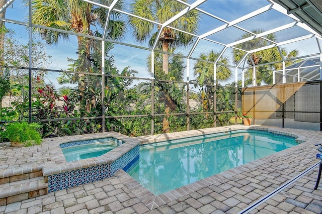 view of pool with an in ground hot tub, a patio, and glass enclosure