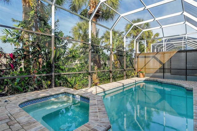 view of pool with an in ground hot tub and glass enclosure