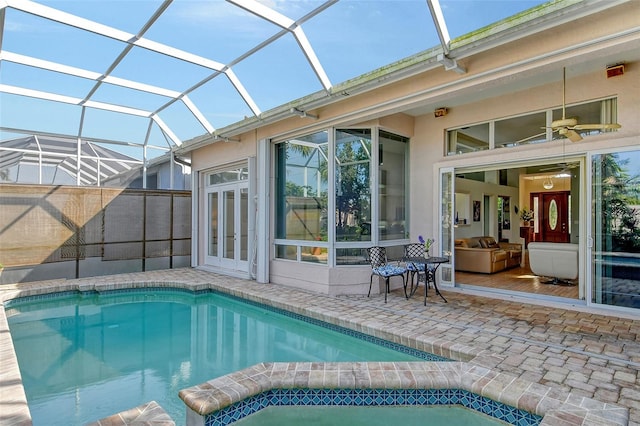 view of pool with french doors, ceiling fan, a lanai, and a patio