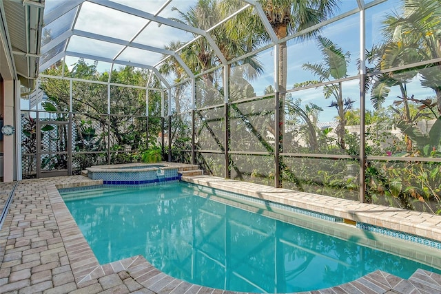 view of swimming pool featuring an in ground hot tub and a lanai