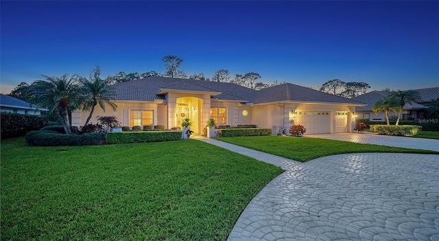 view of front of house with a garage and a lawn